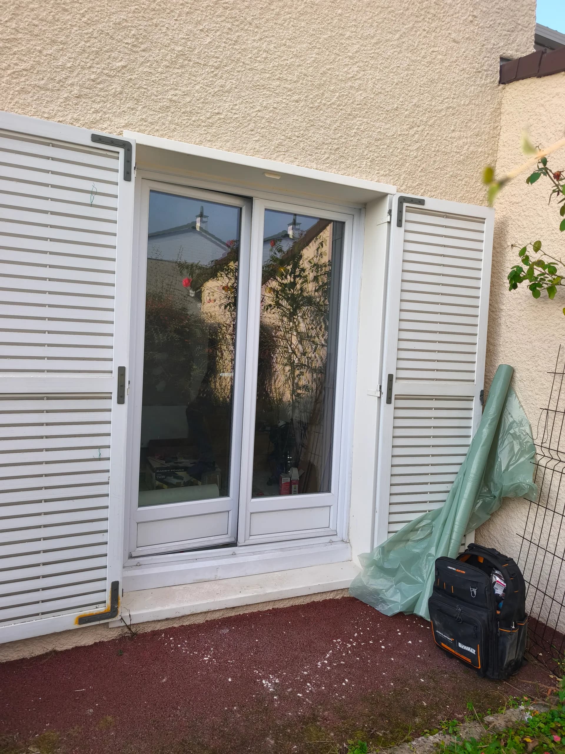 Ancienne porte-fenêtre blanche avec volets battants