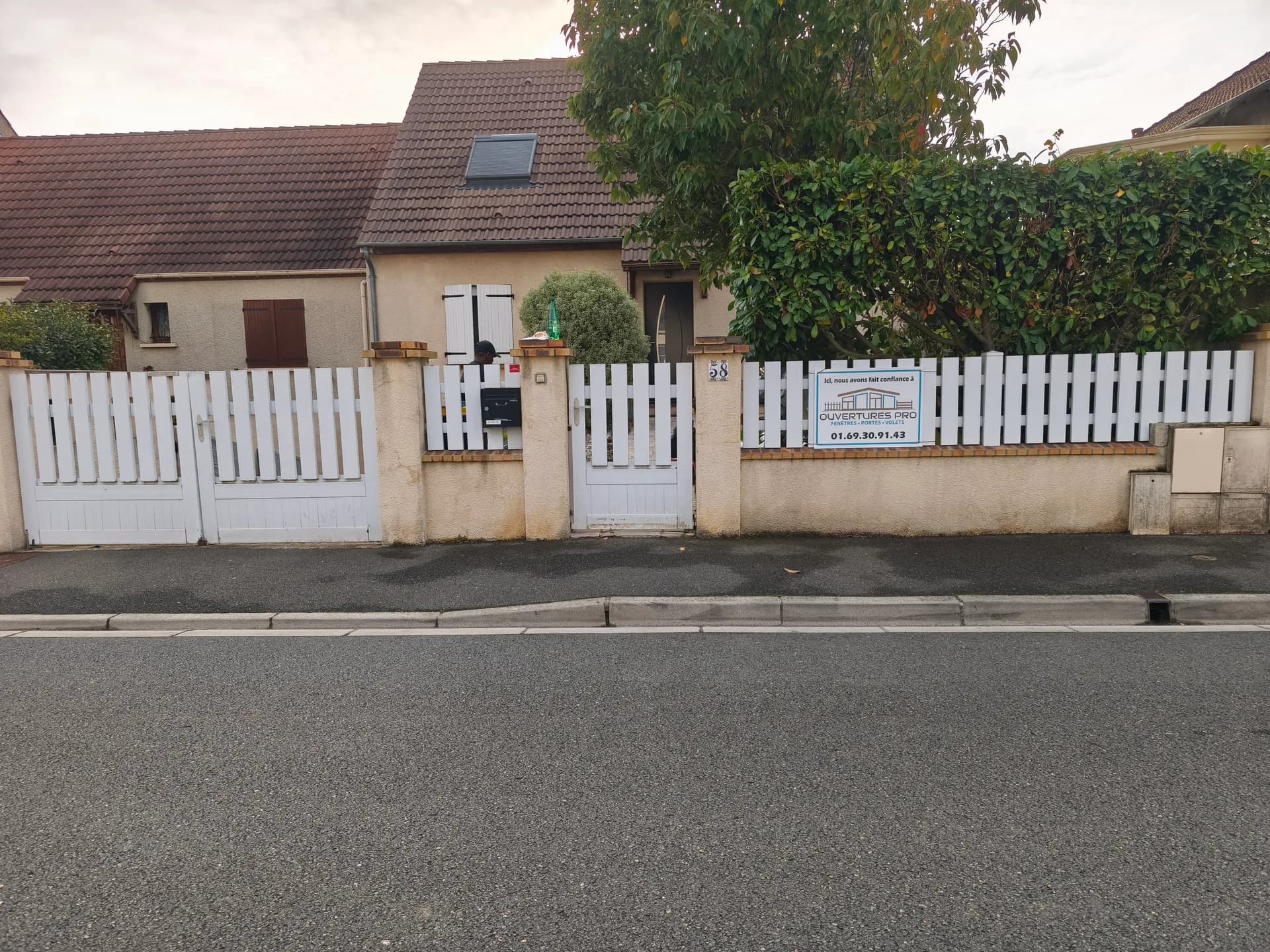 Portail battant et clôture en bois blanc usé par le temps
